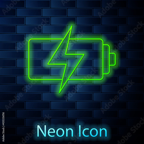 Glowing neon line Battery icon isolated on brick wall background. Lightning bolt symbol. Vector