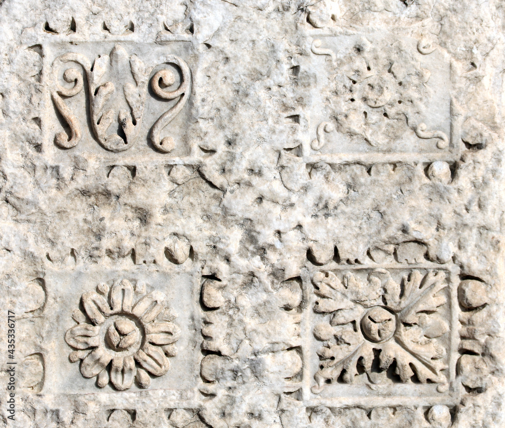 Obraz premium Ancient carved ornament with flower on a stone wall