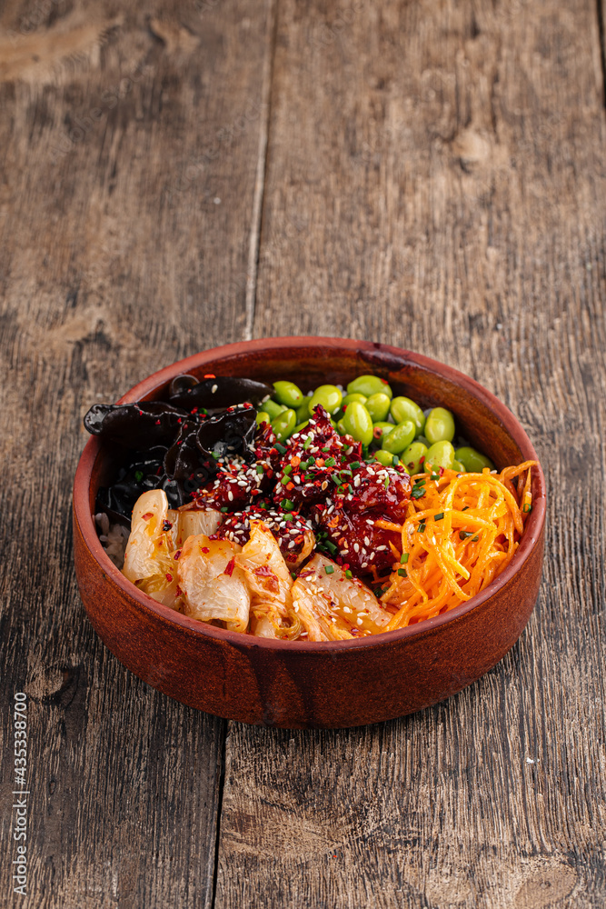 Hawaiian spicy chicken poke bowl with kimchi on purple background Hawaiian spicy chicken poke bowl with kimchi on purple background