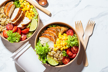 Chicken and quinoa salad with corn and tomatoes in plastic-free bowl. Zero waste, to go food, recycling packaging, eco friendly concept.