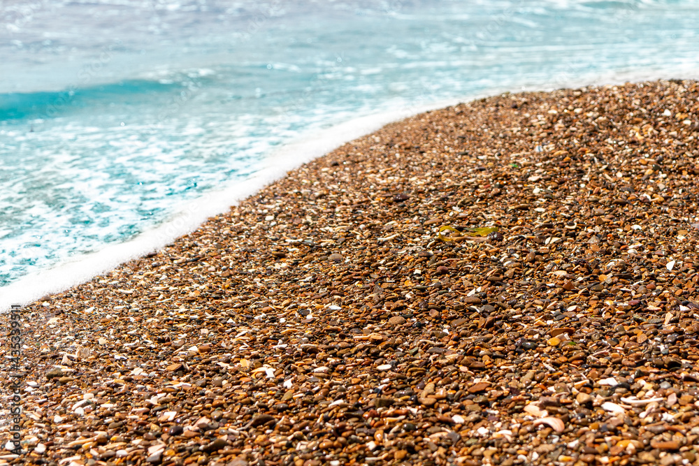 Background of brown sea pebbles with parts of white seashells Background of brown sea pebbles with parts of white seashells