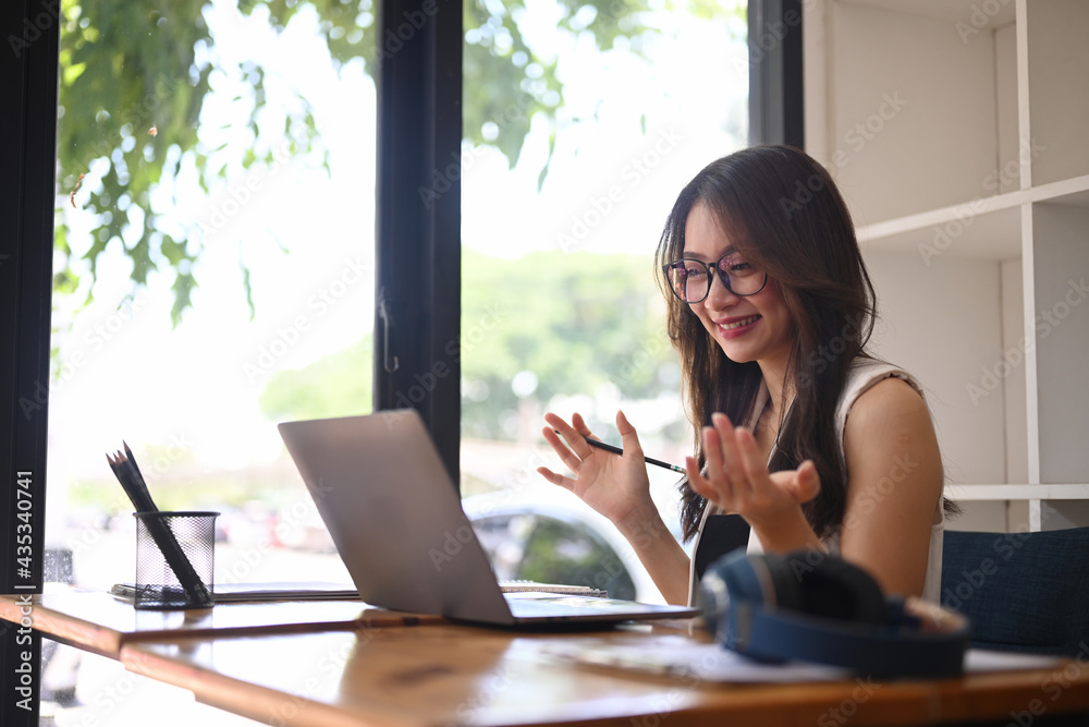 Happy asian woman having video call with her friends on laptop. Happy asian woman having video call with her friends on laptop.