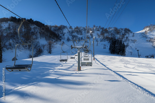 天気の良い日本のスキーリゾートでスキーをする人