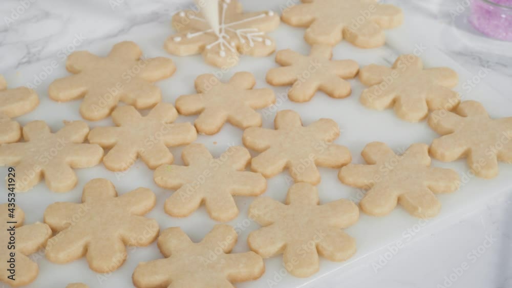 Time lapse. Step by step. Icing snowflake shaped sugar cookies with white royal icing. Time lapse. Step by step. Icing snowflake shaped sugar cookies with white royal icing.