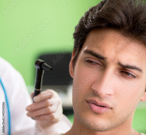 Female doctor checking patient's ear during medical examination