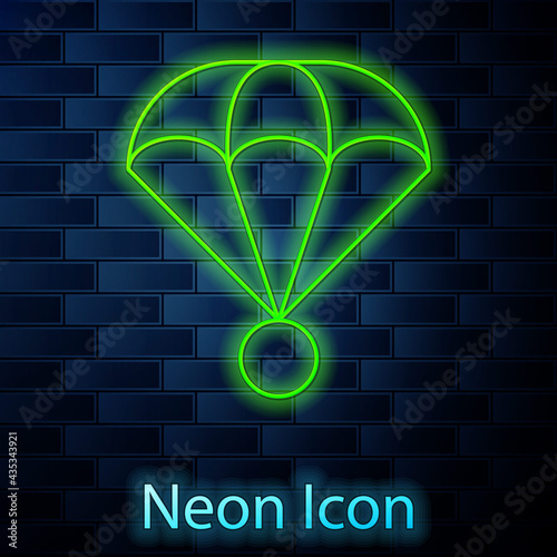Glowing neon line Parachute icon isolated on brick wall background. Extreme sport. Sport equipment. Vector