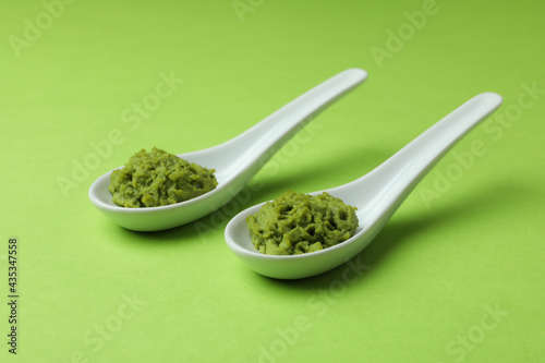Photo Ceramic spoons with wasabi on green background