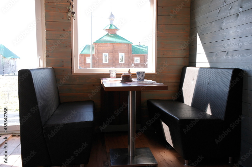 Fototapeta premium sofas and a table by the window in the dining area of the frame house