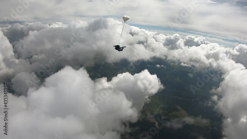 Skydiving. Tandem jump. Two people are falling in the amazing cloudy sky.