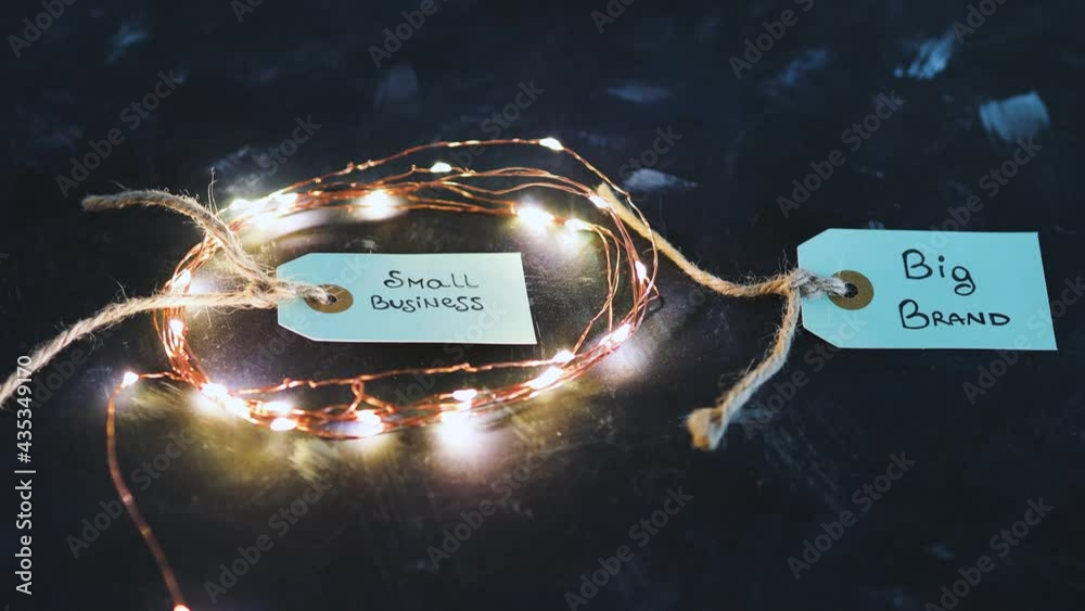 product tags with small business vs big brand texts with fairy lights on the small one, concept of customer behaviour and supporting small businesses