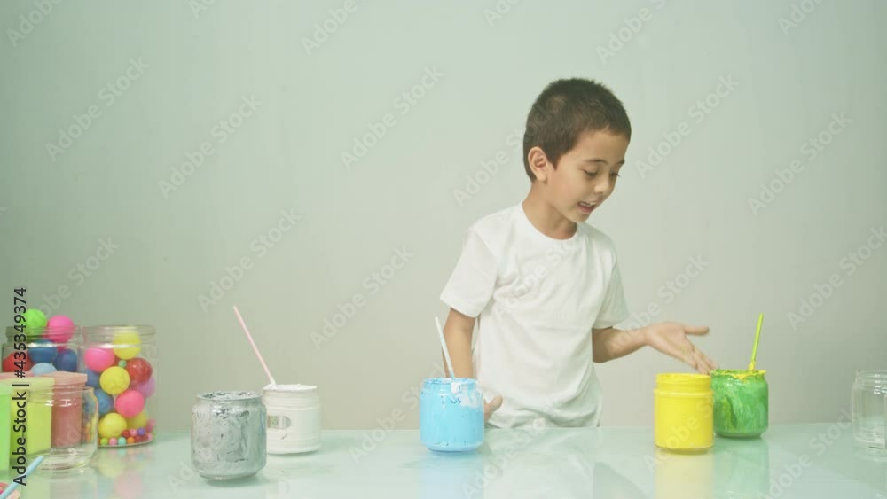 A boy was joyfully mixing a new color..Boy mixing colors Learning materials in school, Montessori method that children manage..high quality 4K video studio shot. colorful background. A boy was joyfully mixing a new color..Boy mixing colors Learning materials in school, Montessori method that children manage..high quality 4K video studio shot. colorful background.