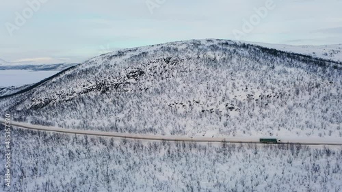 Aerial view of a lorry driving on boreal road, in Kasivarsi wilderness area, Lapland - pan, drone shot photo