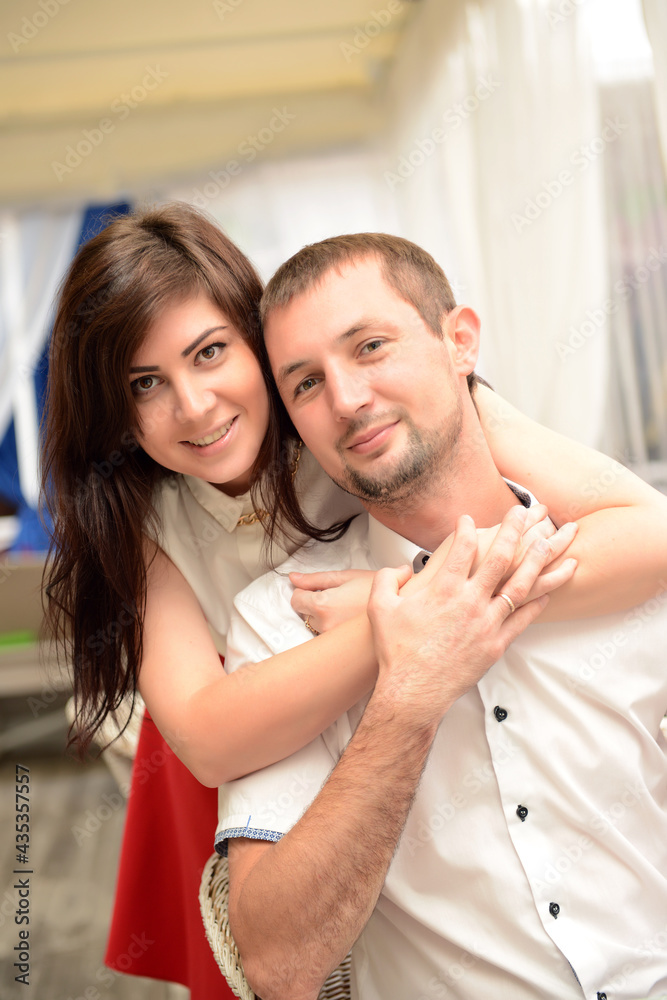 Fototapeta premium The girl hugged her boyfriend, putting her hands on his shoulders.