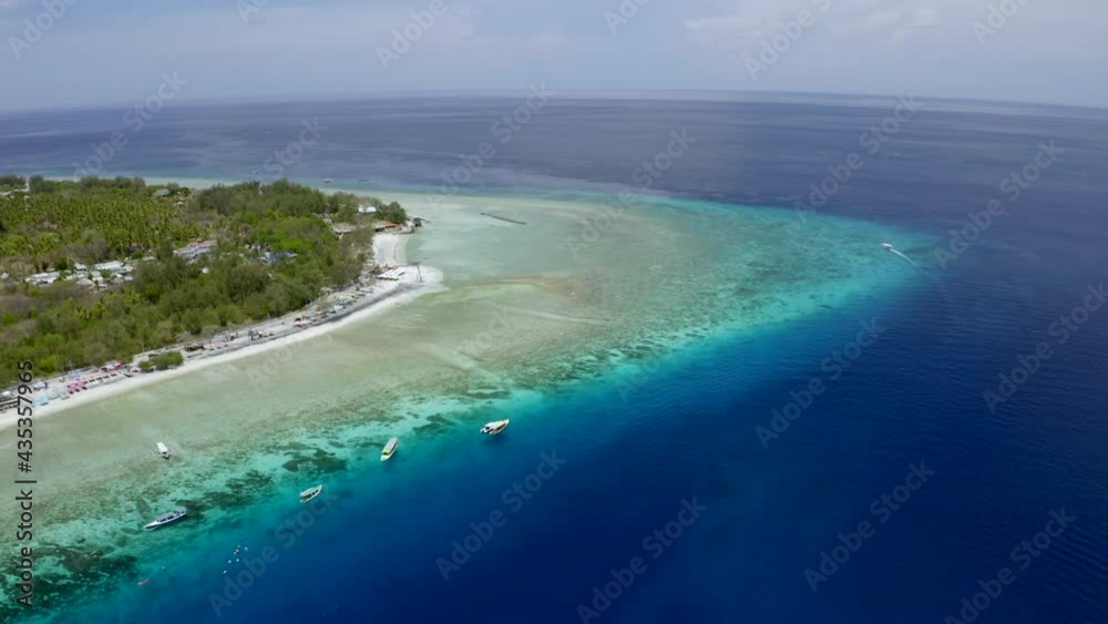 Aerial Panning The Shoreline Of A Coral Reef Island, With Deep Blue See And Small Boats Anchored Nearby - Gili, Indonesia Aerial Panning The Shoreline Of A Coral Reef Island, With Deep Blue See And Small Boats Anchored Nearby - Gili, Indonesia