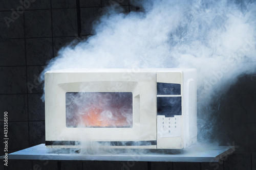 Obraz na plátně Microwave oven burns, house fire due to improper operation, spontaneous combusti
