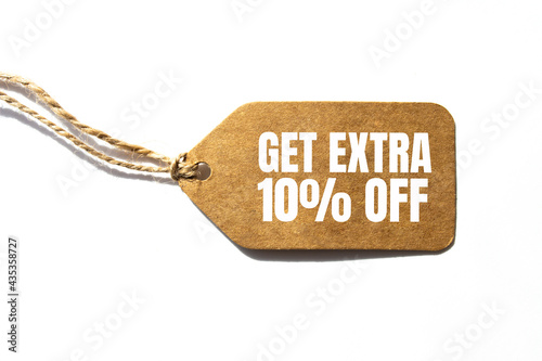 GET EXTRA 10 OFF percent text on a brown tag on a white paper background