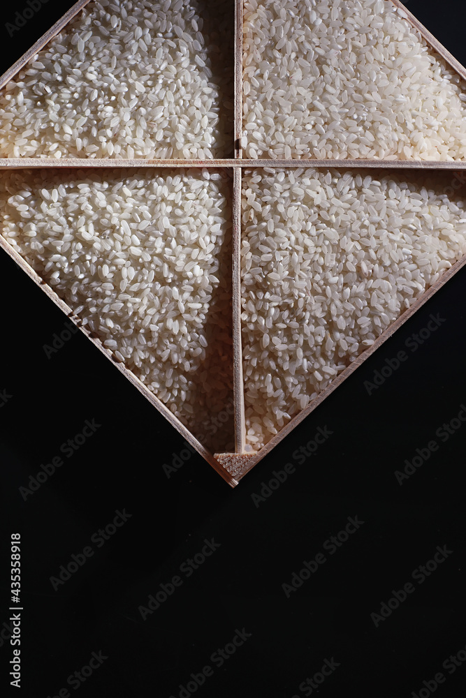 Fototapeta premium A set of grain cereals. Rice, buckwheat and millet groats in a wooden tray. A grocery set of cereals. Import of grain.