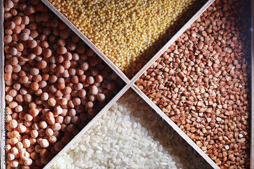 A set of grain cereals. Rice, buckwheat and millet groats in a wooden tray. A grocery set of cereals. Import of grain. A set of grain cereals. Rice, buckwheat and millet groats in a wooden tray. A grocery set of cereals. Import of grain.
