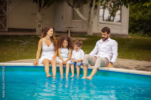 Happy Family sitting by the pool.