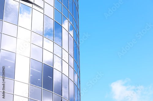 Architectural detail of the facade with multiple reflections of other buildings and the sun. Modern building. Architecture background