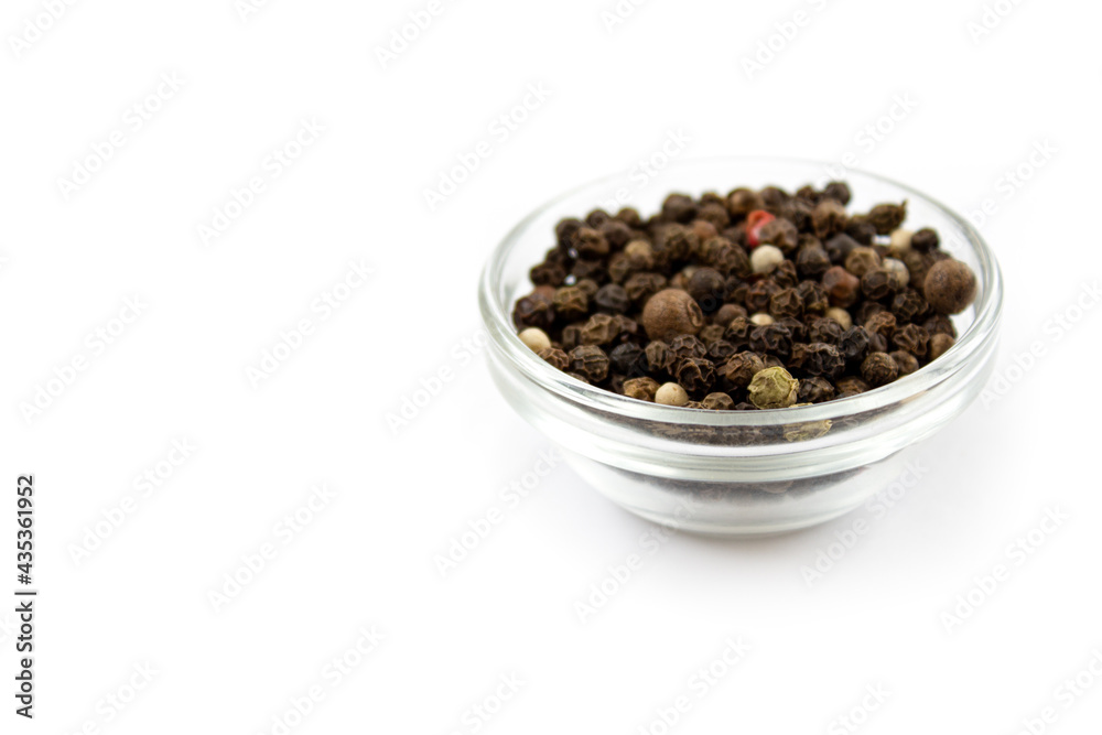 Pepper mix. Black, red and white peppercorns in a glass cup, isolated on white background. Close-up.