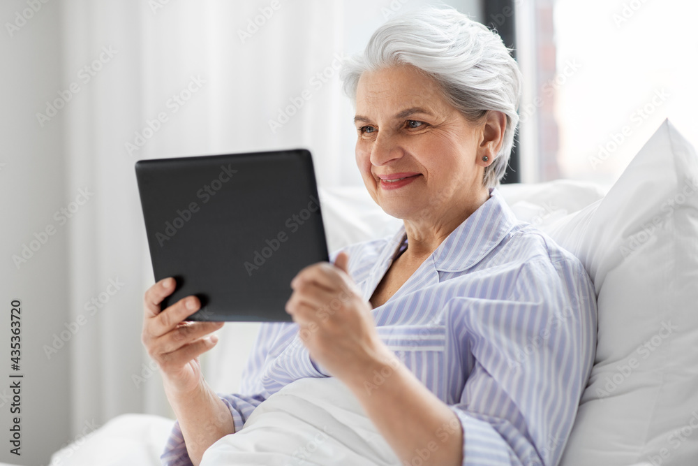 technology, old age and people concept - senior woman with tablet pc computer in bed at home bedroom technology, old age and people concept - senior woman with tablet pc computer in bed at home bedroom