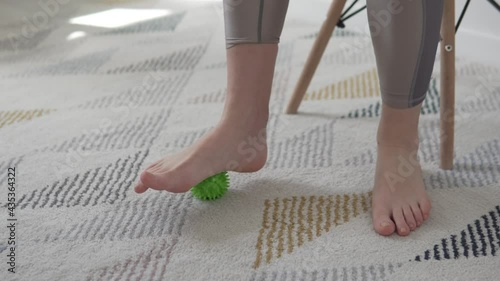 Close-up, the woman's leg rolls a massage ball with thorns. Preventing flat feet photo