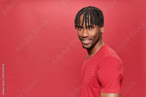 Smiling black man with red t-shirt looking at camera on red background
