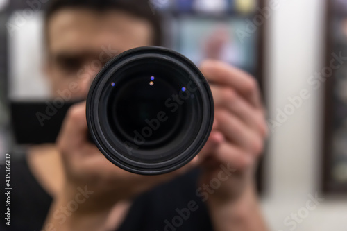 Close-up lens in the hands of a man on a blurred background.