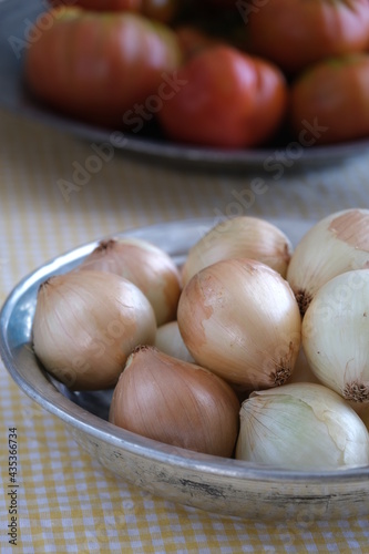 White onions on a copper plate on the table