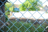 Metallic blue mesh on a green blurred background. Selective focus. Blue grid