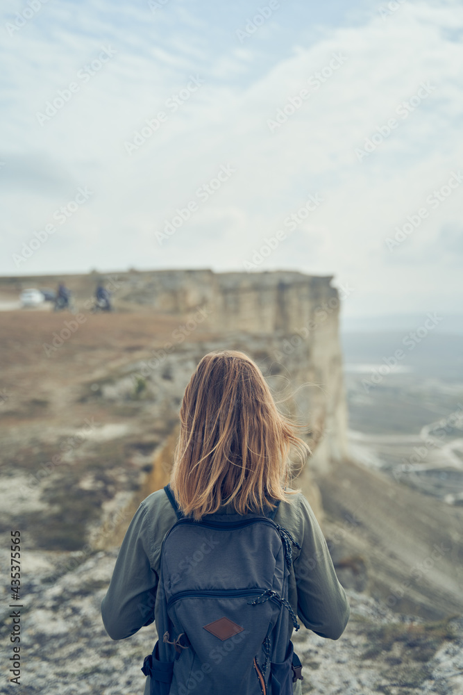 Woman stay on a rock, looking at the landscape and enjoying the view and fresh air.