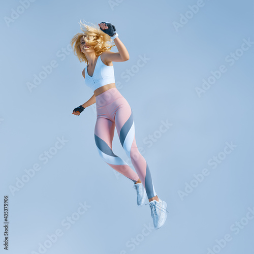 Sportswoman jumping and stretching. Motivation fitness concept photo