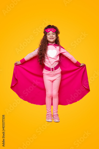 Positive little superhero showing cape