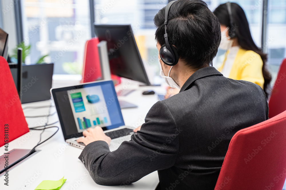 Call center team wearing face mask while working together in office. Call center team wearing face mask while working together in office.