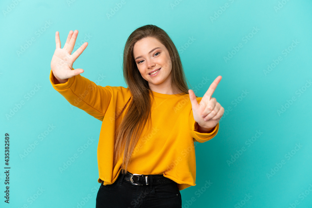 Teenager girl over isolated blue background counting seven with fingers Teenager girl over isolated blue background counting seven with fingers