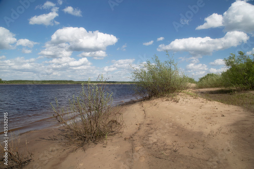 Landscape on the river in summer with a bare sky and clouds.