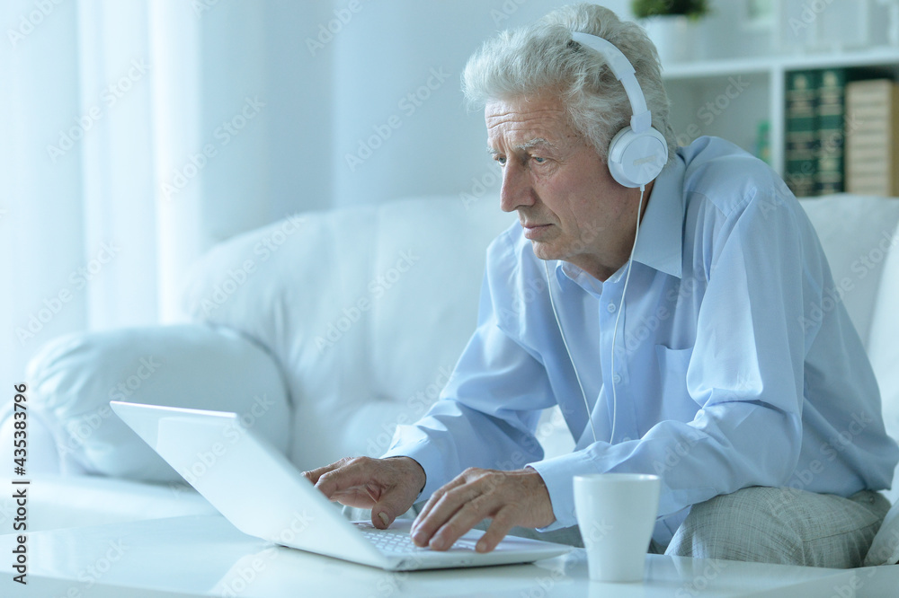 Emotional senior man using laptop at home Emotional senior man using laptop at home