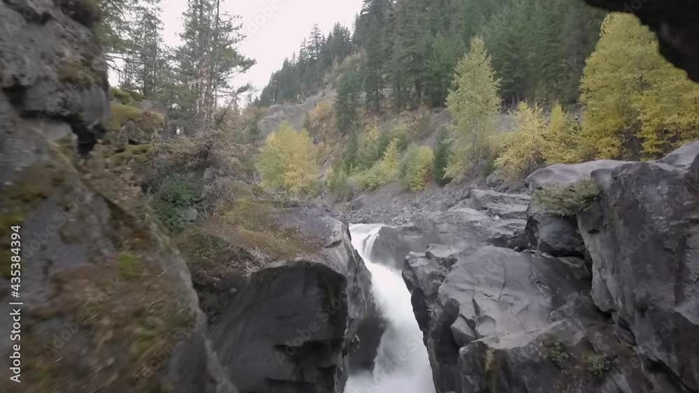 First-person aerial view between rocky walls and above mountain stream and waterfall. Spain First-person aerial view between rocky walls and above mountain stream and waterfall. Spain