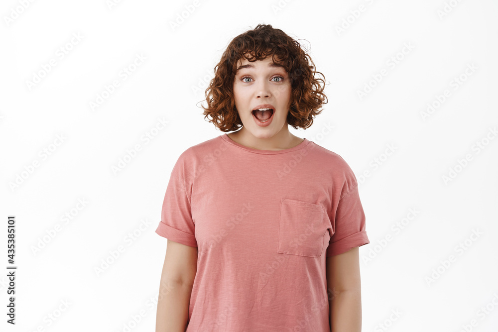 Wow omg. Impressed young woman drop jaw, gasping and looking excited and astonished, blown away by awesome advertisement, promo deal, standing over white background Wow omg. Impressed young woman drop jaw, gasping and looking excited and astonished, blown away by awesome advertisement, promo deal, standing over white background