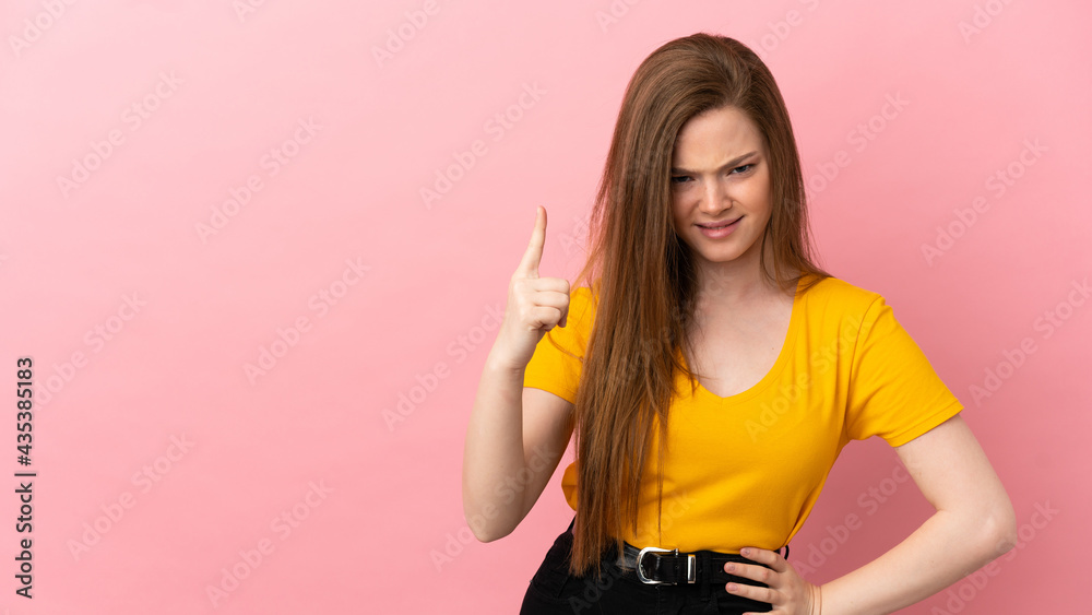 Teenager girl over isolated pink background frustrated and pointing to the front Teenager girl over isolated pink background frustrated and pointing to the front