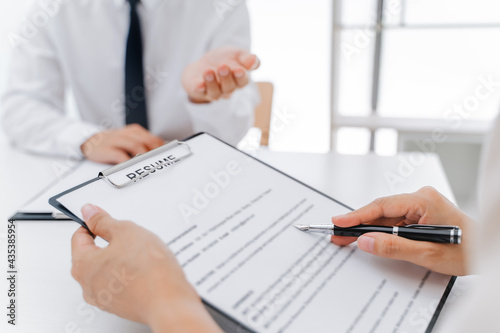 Examiner reading a resume during job interview at office