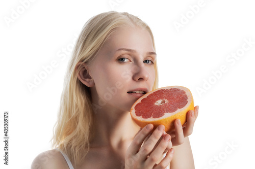 Young blonde woman with grapefruit in hands isolated on white background.