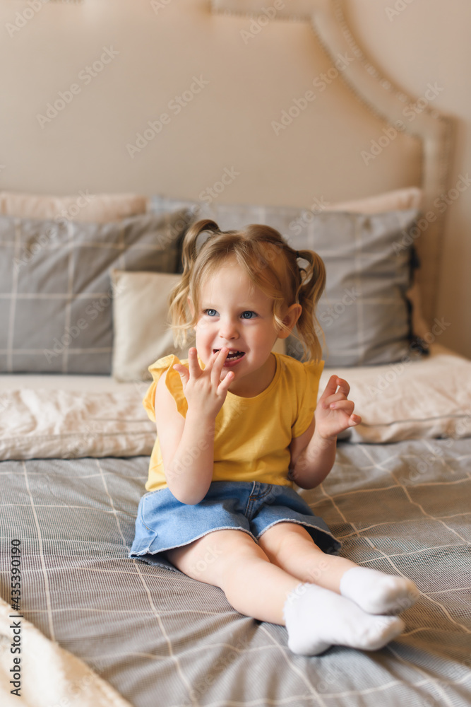 Portrait of little preschool girl fooling around on bed at home Portrait of little preschool girl fooling around on bed at home