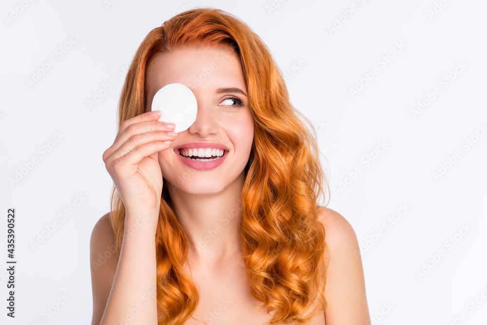 Photo portrait of young model with curly red hair smiling covered eye with cotton disk laughing looking copyspace isolated on white color background Photo portrait of young model with curly red hair smiling covered eye with cotton disk laughing looking copyspace isolated on white color background