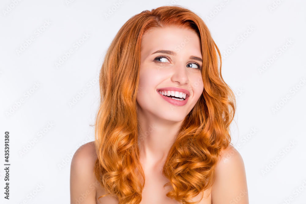 Photo portrait of pretty girl with wavy ginger hair smiling with naked shoulders looking empty space isolated on white color background Photo portrait of pretty girl with wavy ginger hair smiling with naked shoulders looking empty space isolated on white color background