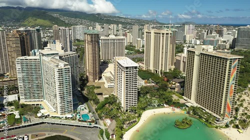 Cinematic 4K dolly aerial drone footage of high-rise hotels on the shore of Waikiki, vibrant, popular tourist destination near Honolulu on Oahu island in Hawaii known for its popular surf beach photo