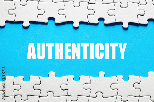 The word authenticity framed by jigsaw puzzle pieces. To discover or reveal the truth, reality or reliability photo