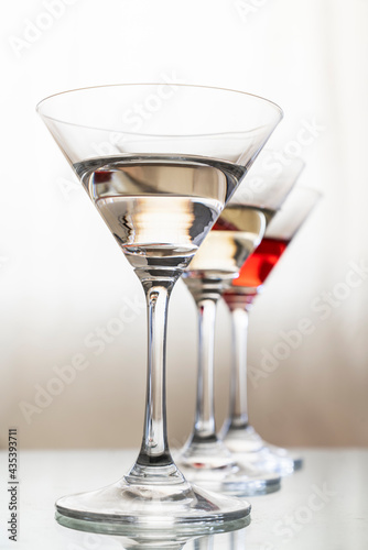 cocktail or champagne glasses on a warm beige background. concept for a beverage bar, vertical photo