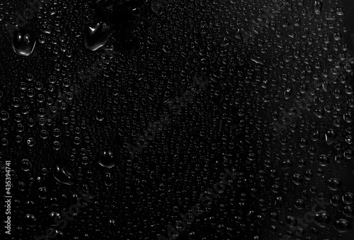 water drops on black background. abstract dew water droplets on a window glass for photo overlay effect or giving fresh effect on beverages mockup. photo